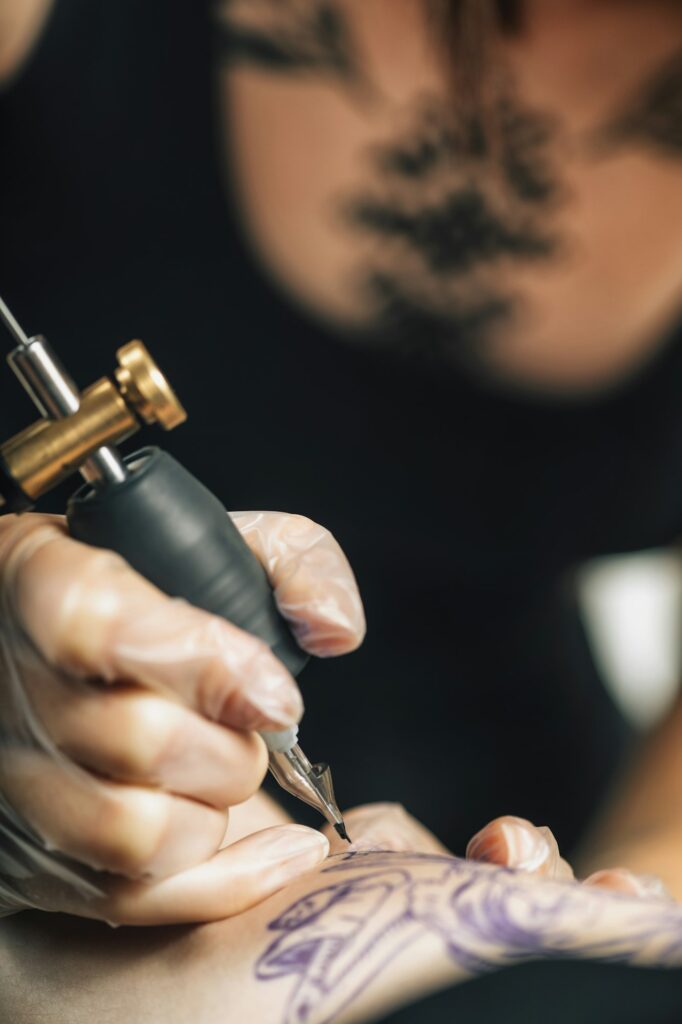 Tattoo Machine Close Up. Tattoo Artist Creating Tattoo on a Man's Arm